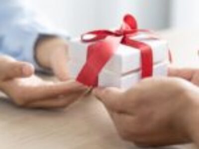 A person handing a gift to someone else.